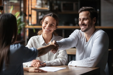 couple shaking local insurance agents hand